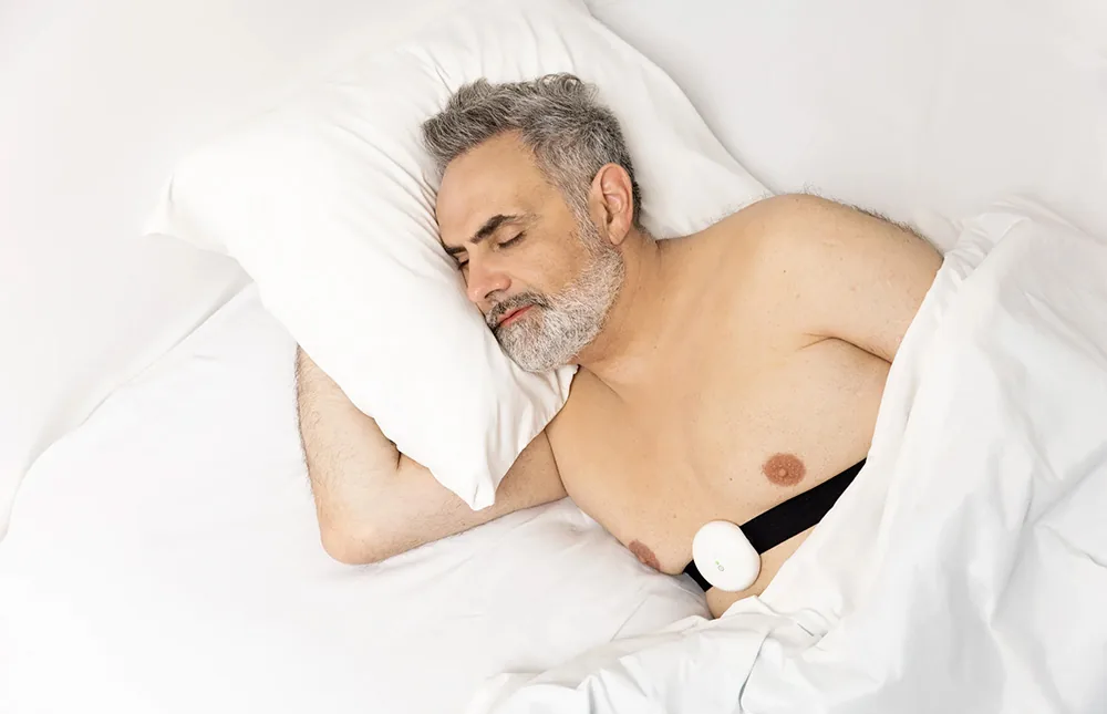 Kobieta śpi w domu z Aidmed One i pulsoksymetrem napalcowym